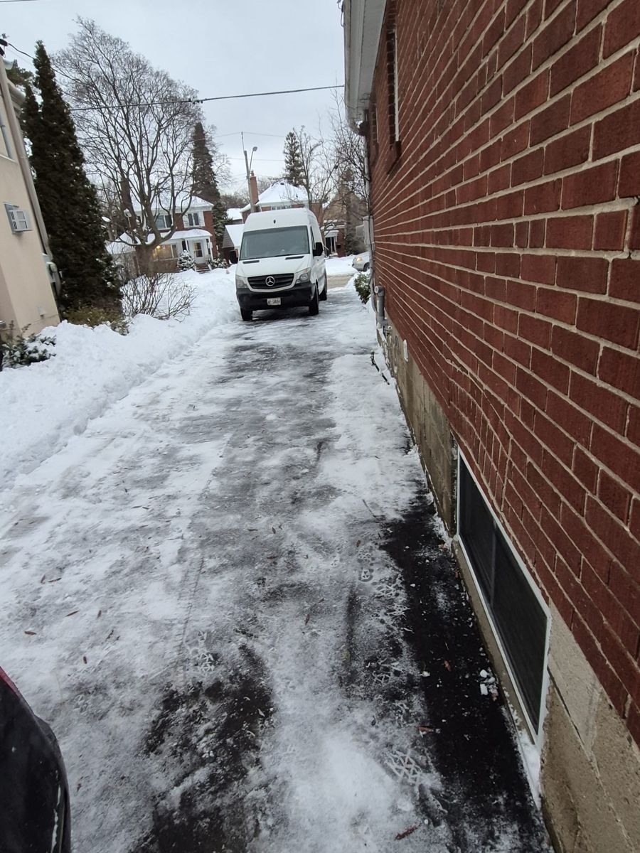Narrow drive along a brick home scraped down to the pavement after a storm